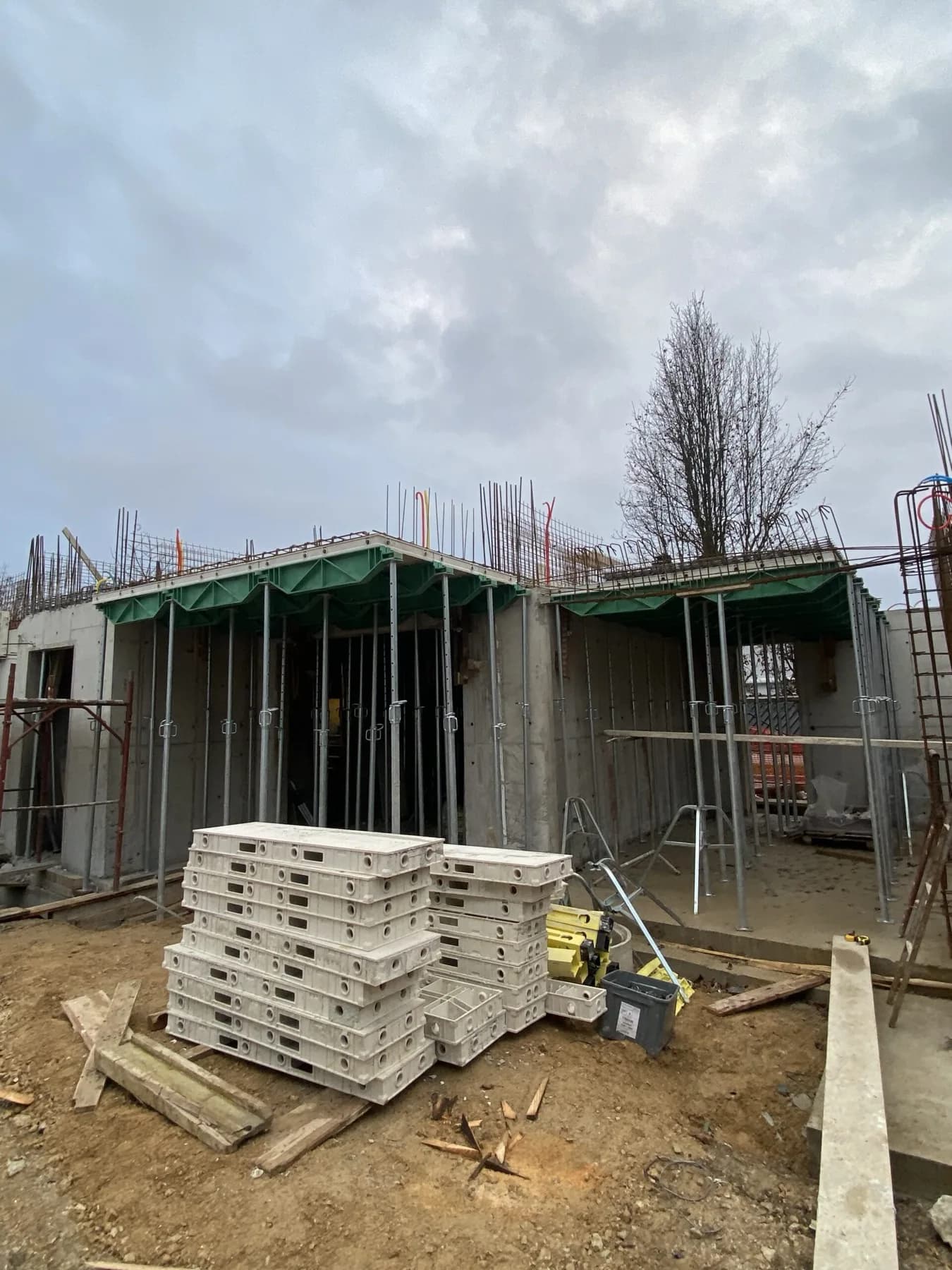 ECOPA formwork walls and stacked composite panels on a construction site